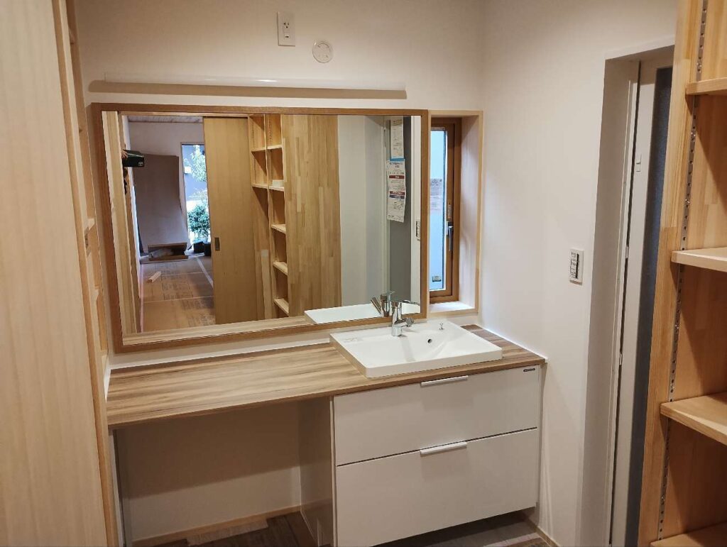 洗面化粧台ミラー。窓高さに合わせたデザインとなっている。