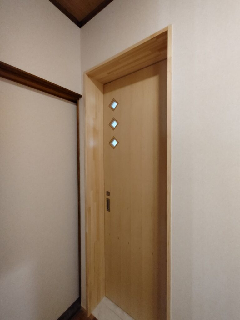 トイレ建具にはデザインを兼ねた採光窓を取り付けた