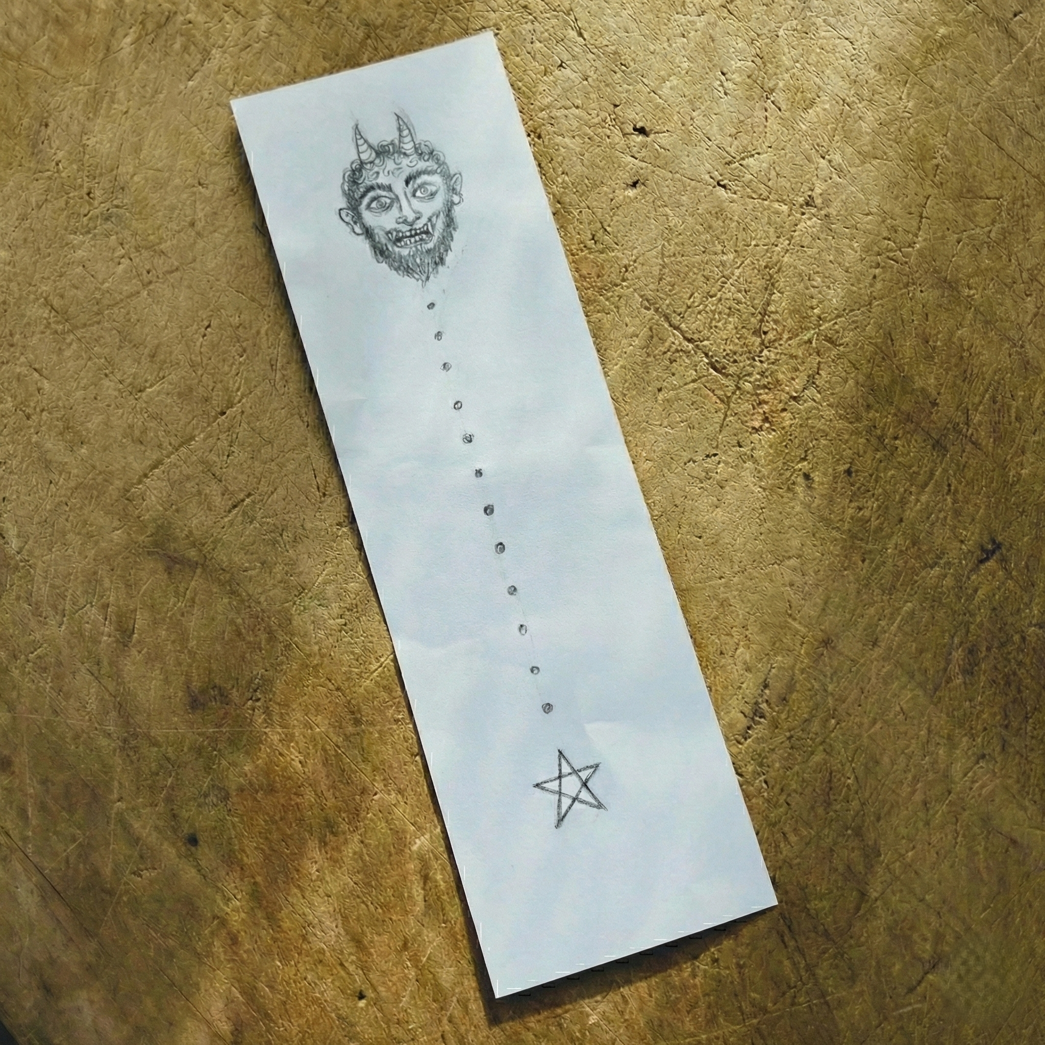 岐阜県東濃地方に伝わる節分の風習「鬼めくり」「鬼ふだ取り」のお札。短冊に、鬼の顔、ドット、五芒星を描く。